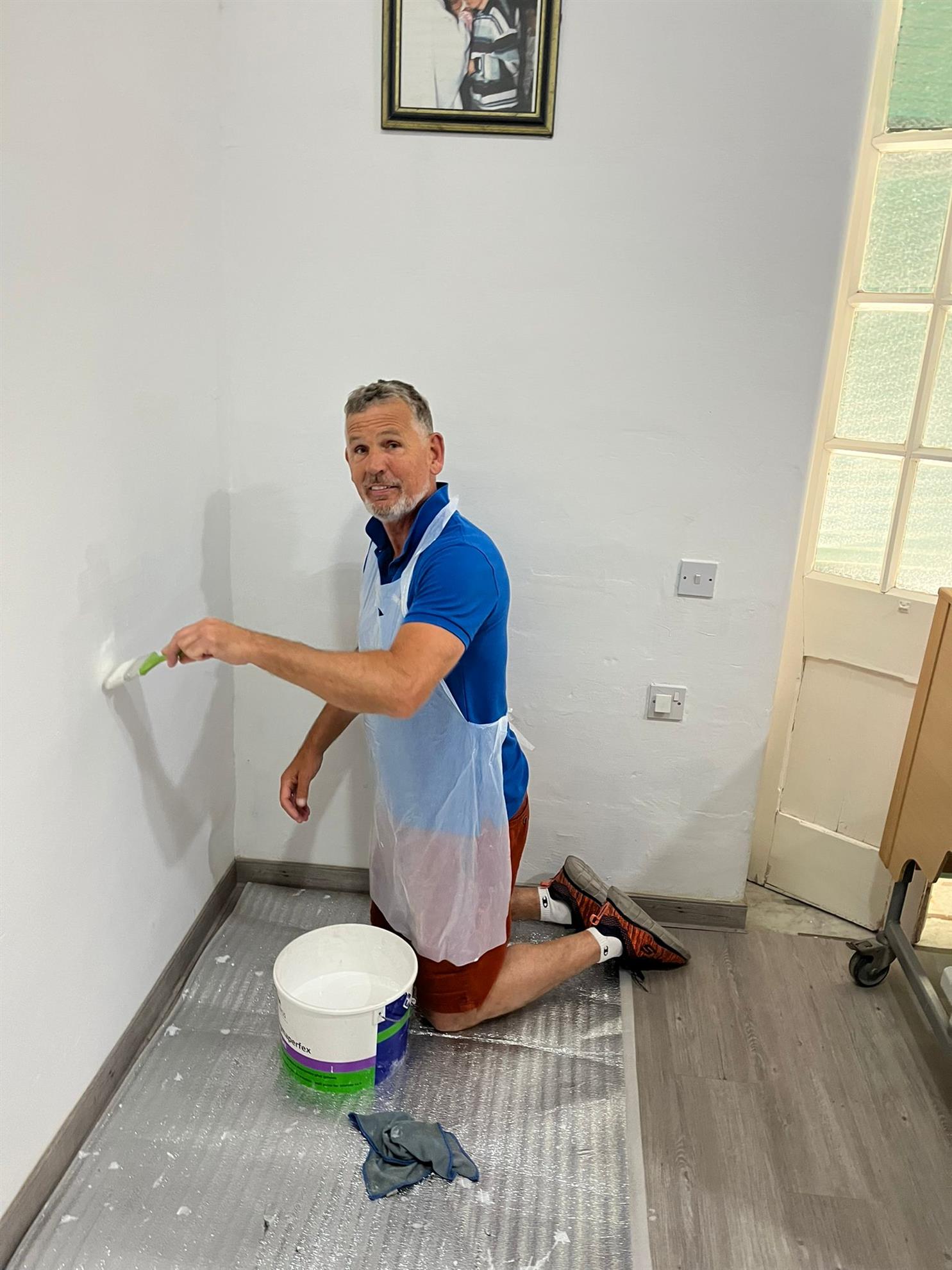 A club member repainting a room at Dar il-Kaptan with a roller